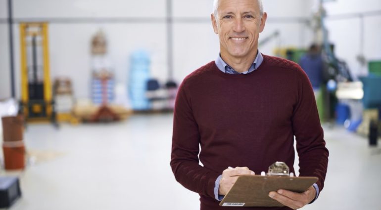 Portrait of a factory manager standing with a clipboard